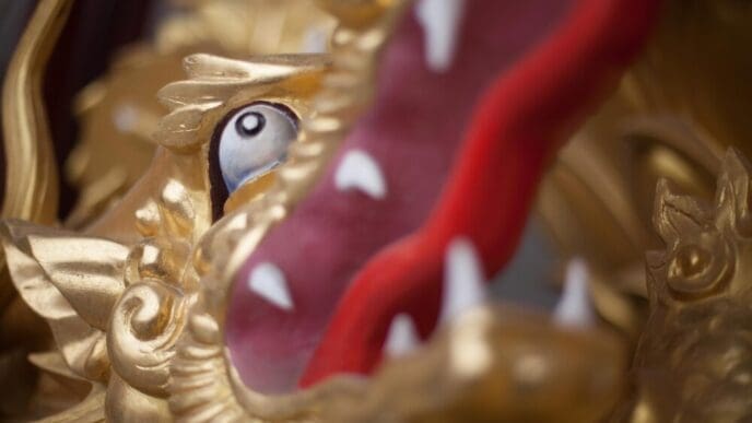 Close-up of a gilded dragon sculpture, showcasing intricate details and a shimmering gold finish.