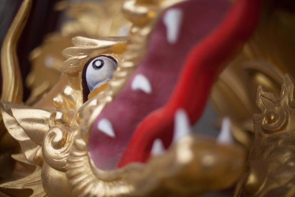Close-up of a gilded dragon sculpture, showcasing intricate details and a shimmering gold finish.