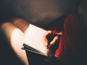Close-up of a hand holding a piece of paper in a home setting.