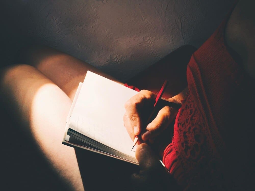 Close-up of a hand holding a piece of paper in a home setting.