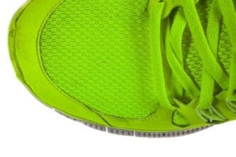Close-up of running shoes with black soles and white uppers on a white background.