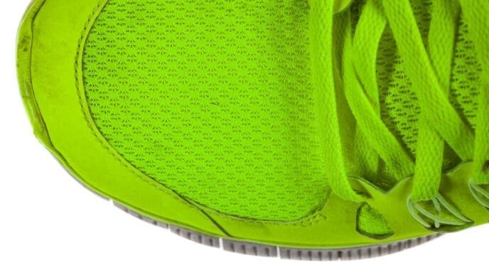 Close-up of running shoes with black soles and white uppers on a white background.