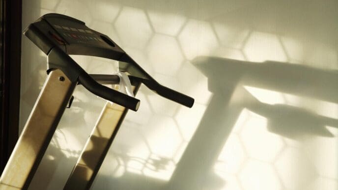 Close-up of a home treadmill showing the control panel, belt, and handrails.