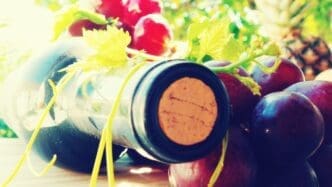 A close-up shot shows a wine bottle next to a cluster of grapes.