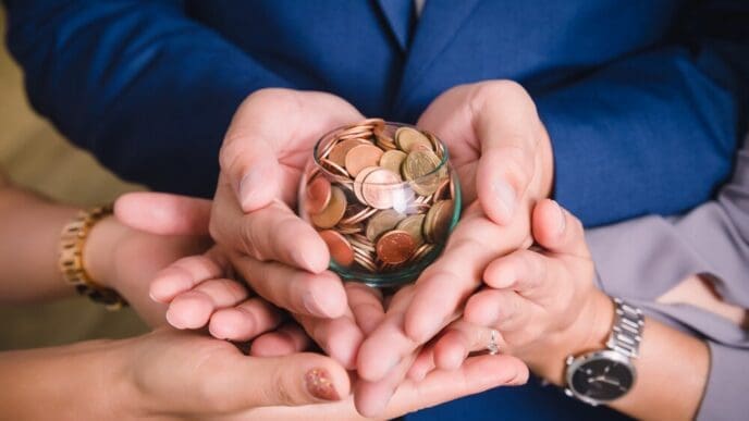 Hands holding a stack of coins, illustrating the concept of saving money.