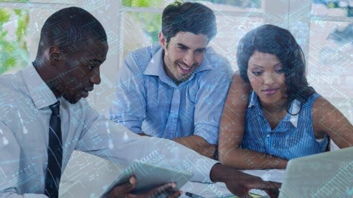 A close-up of a computer circuit board is overlaid on business people using a laptop.