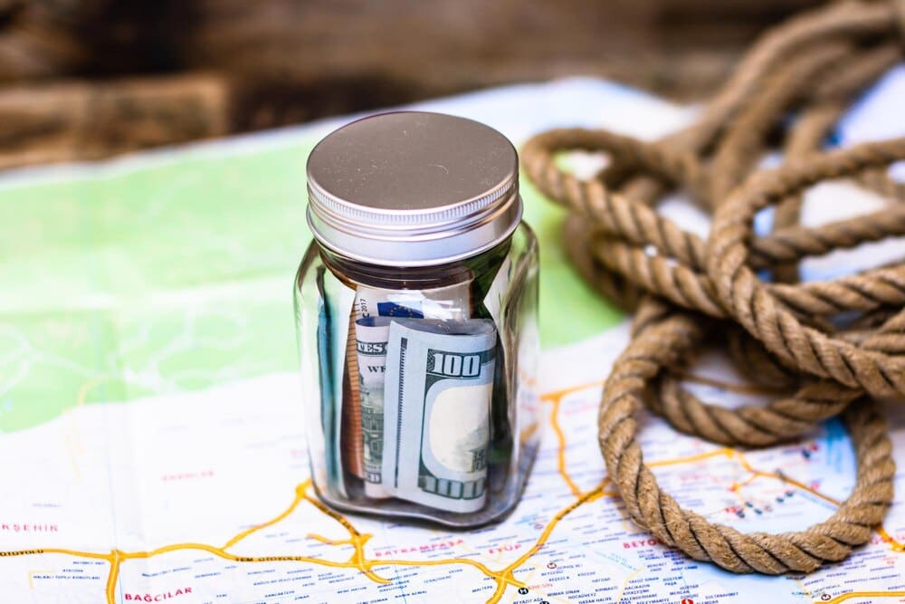 Close-up of a glass jar filled with folded banknotes, symbolizing saving for future goals.
