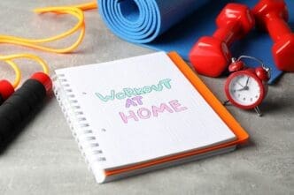 Copybook and fitness equipment, including weights, sit on a gray surface.