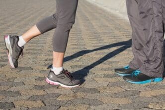 Two people in running shoes face each other.