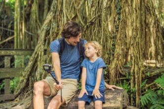 A father and son take a selfie while exploring the Ubud Monkey Forest in Bali.