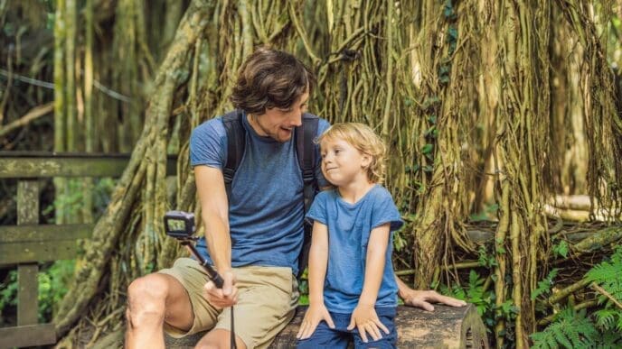 A father and son take a selfie while exploring the Ubud Monkey Forest in Bali.