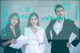 Business colleagues stand together in an office, gesturing toward a projected image on an invisible screen.