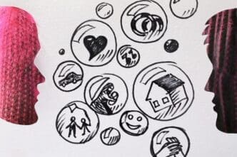 Conceptual image of two cactuses viewed through man and woman-shaped cutouts in white paper, with various drawings on the paper.