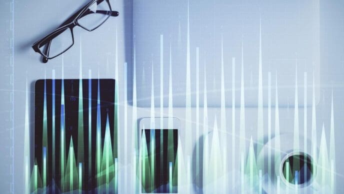 Double exposure shows a forex chart hologram overlaid on a desktop with a phone, illustrating a mobile trading platform concept.