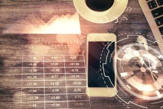 Double exposure of a forex trading chart hologram overlaid on a desktop with a phone.