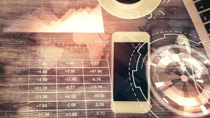 Double exposure of a forex trading chart hologram overlaid on a desktop with a phone.