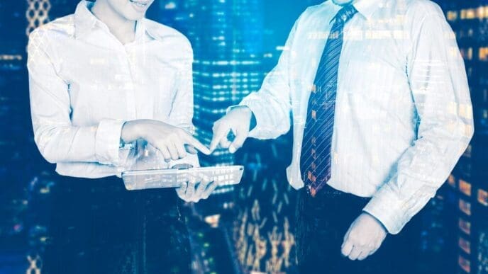 Double exposure shows two business people, one using a tablet, layered with the other.