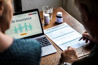 An elderly couple reviews documents together, presumably planning their life insurance.