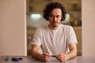 A person prepares a vape device for use by packing it with ground material.