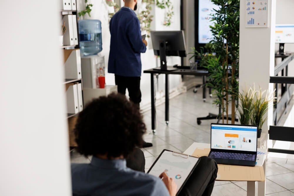 An entrepreneur analyzes financial reports, profit, sales, and investment data on a laptop screen.