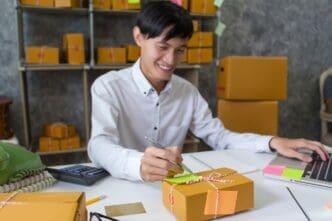 Young man taking notes about customer information, likely for shipping and delivery.