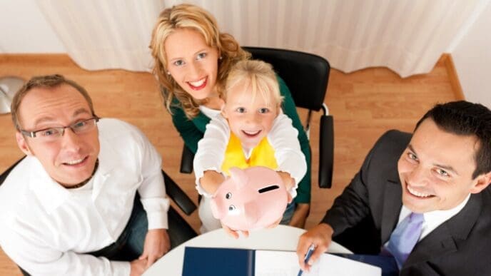 A family sits at a table with a financial consultant, discussing finance and insurance options.