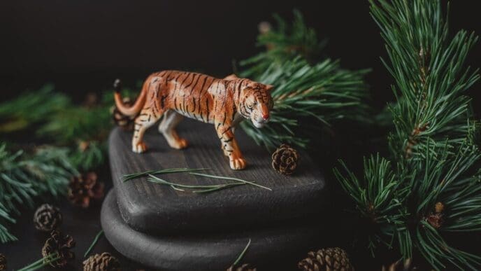 A figurine of a tiger, a symbol of the 2022 Chinese New Year, is surrounded by pine branches and cones.