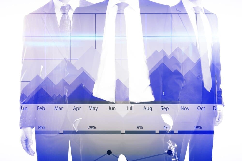 Two people in business attire shaking hands in front of a rising bar graph.