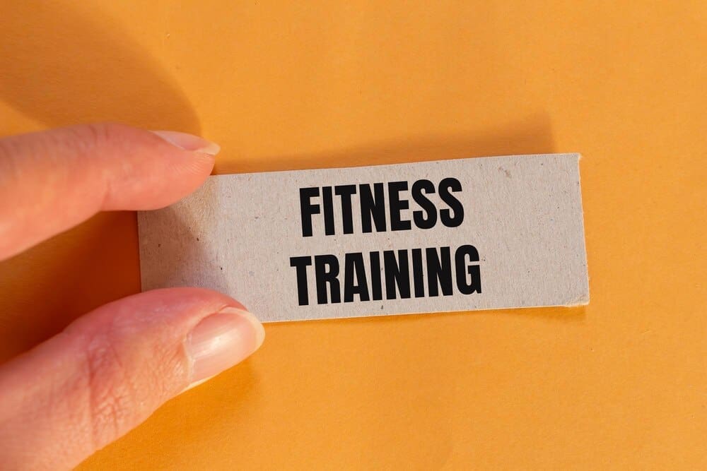 Ripped paper with a fitness training message is set against an orange background with copy space.