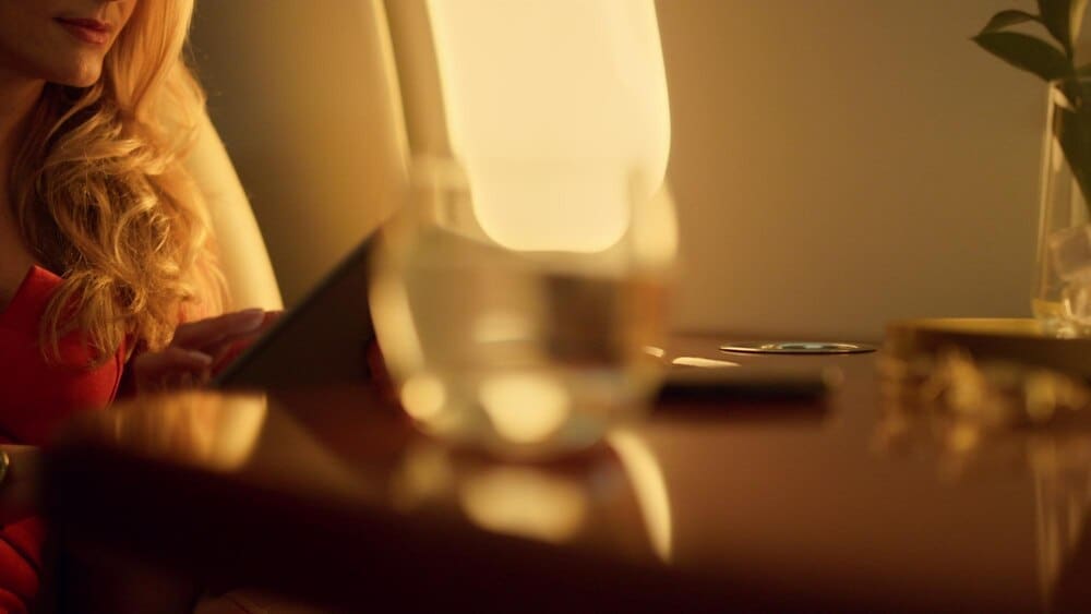 A close-up shot shows a woman with focused eyes touching a tablet computer.