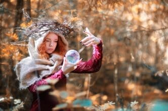 A person in a forest setting conducts a ritual, likely a fortune-telling session.
