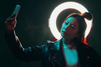 A neon-lit cyberpunk portrait features a girl taking a selfie with futuristic gadgets.