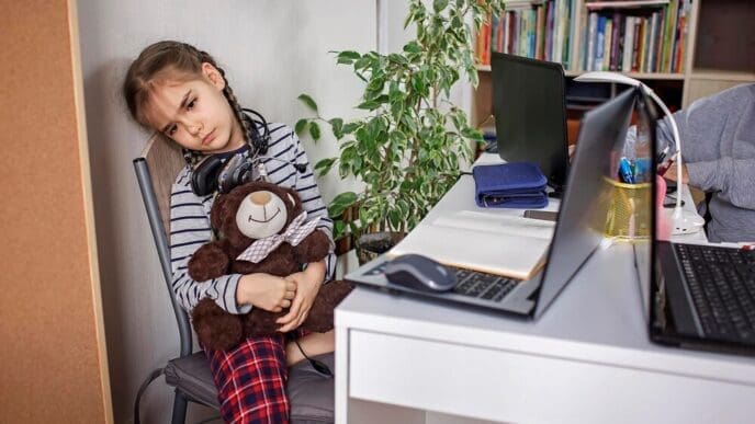 A young girl sits on a table in a domestic setting.