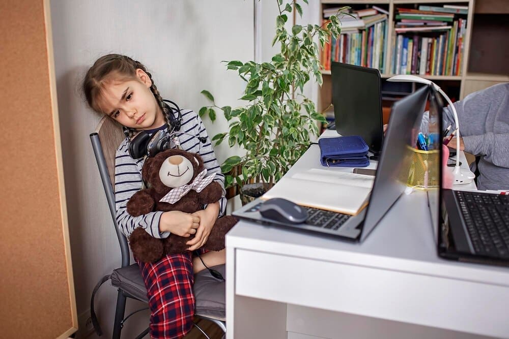 A young girl sits on a table in a domestic setting.