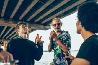 A diverse group of friends laughs and enjoys a summer day, possibly at a party.