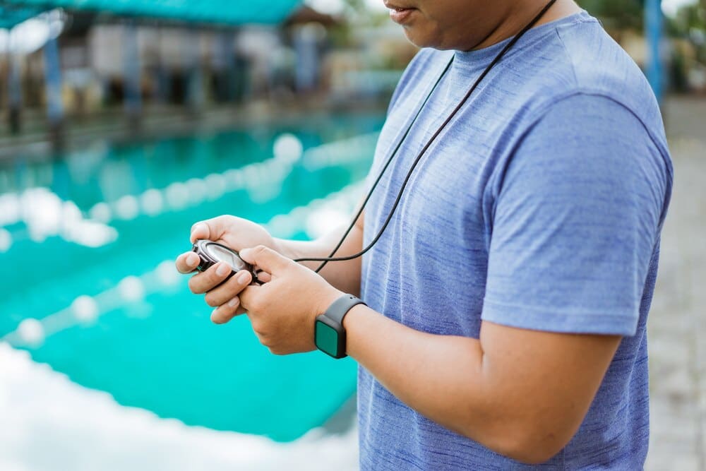 Hands of an instructor setting a stopwatch.