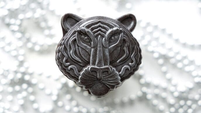 A chocolate tiger figure, representing the Chinese New Year, is set against a gray background with soft lights.