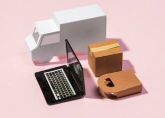 High-angle shot of a delivery truck interior, featuring a laptop on the dashboard and a package in a box.
