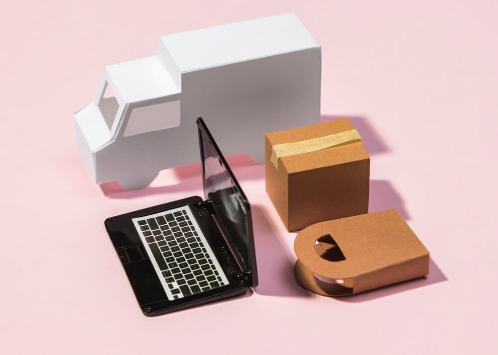 High-angle shot of a delivery truck interior, featuring a laptop on the dashboard and a package in a box.