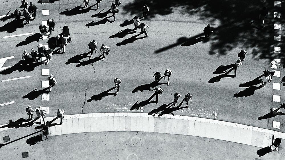 High-angle shot shows people walking along a street.
