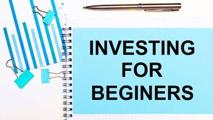 Overhead view of light blue diagrams, paper clips, and a sheet of paper labeled "INVESTING FOR BEGINNERS" on a light surface, representing a business concept.