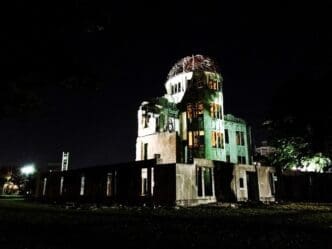 Low-angle view of an illuminated building against a dark night sky in Hiroshima.