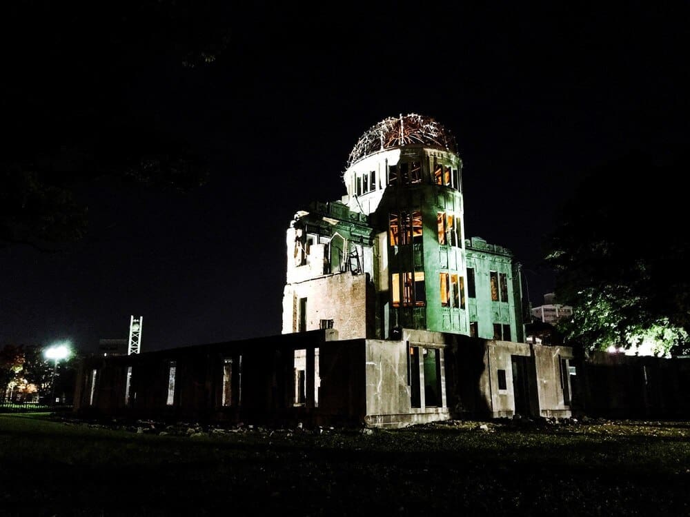 Low-angle view of an illuminated building against a dark night sky in Hiroshima.