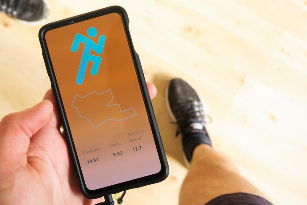 Low-angle shot of a man's torso and hands as he uses a phone.