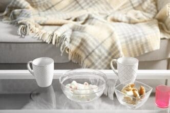 A low table in a living room displays sweets and two cups.