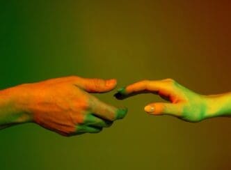 Hands of a man and woman reach toward each other, set against a red and green neon-lit background.
