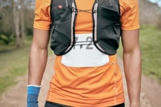 A male marathon runner sprints along a wooded path, likely during a race or outdoor fitness activity.