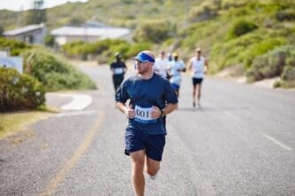 A man participates in an outdoor triathlon, running a street race as part of the competition.