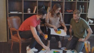 A group of people in a creative business meeting analyze market statistics.