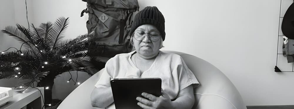 An elderly businesswoman uses a tablet.